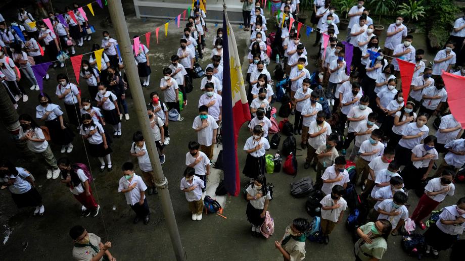 Des élèves assistent à une cérémonie de lever du drapeau lors de l'ouverture des classes à l'école primaire San Juan dans la région métropolitaine de Manille, aux Philippines, le lundi 22 août 2022. (AP Photo/Aaron Favila)