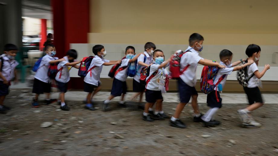 Les élèves font la queue lors de l'ouverture des classes à l'école primaire San Juan dans la région métropolitaine de Manille, aux Philippines, le lundi 22 août 2022. (AP Photo/Aaron Favila)