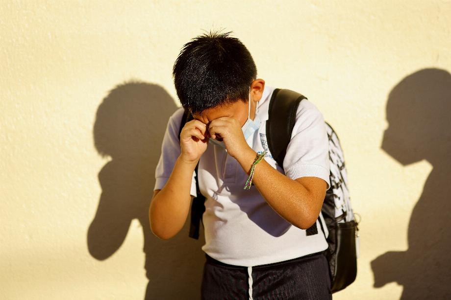 Un garçon se frotte les yeux alors que les élèves du primaire portant des masques de protection retournent pour la première fois aux cours en face à face à temps plein, après avoir suivi des cours en ligne et échelonnés, alors que l'épidémie de maladie à coronavirus (COVID-19) se poursuit, à Ciudad Juarez , Mexique 29 août 2022. REUTERS/Jose Luis Gonzalez