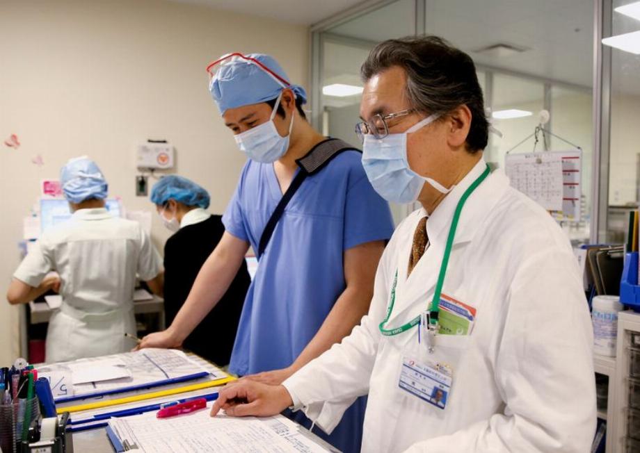 Photo d'archive du Dr Toshiaki Minami, directeur de l'hôpital universitaire médical et pharmaceutique d'Osaka, travaillant avec des collègues de l'aile opérationnelle de l'hôpital au milieu de la pandémie de COVID-19, à Takatsuki, préfecture d'Osaka, au Japon. 17 mai 2021. REUTERS/Akira Tomoshige/File