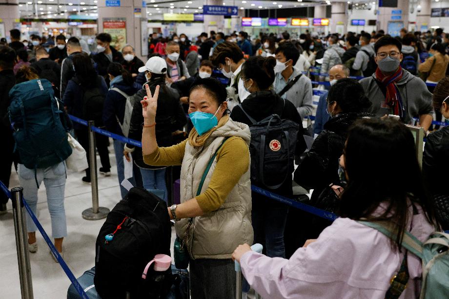 Une femme célèbre au point de contrôle frontalier de Lok Ma Chau à Hong Kong le premier jour où la Chine rouvre la frontière au milieu de la pandémie de maladie à coronavirus (COVID-19) à Hong Kong, Chine, le 8 janvier 2023. REUTERS/Tyrone Siu