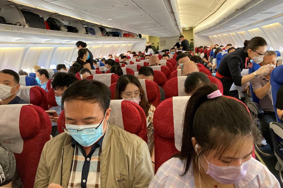 Passagers portant des masques faciaux à la suite de l'épidémie de maladie à coronavirus (COVID-19) sur un vol de China Eastern Airlines à l'aéroport international de Shenzhen Baoan à Shenzhen, province du Guangdong, Chine le 19 mai 2020. REUTERS/Martin Pollard/File