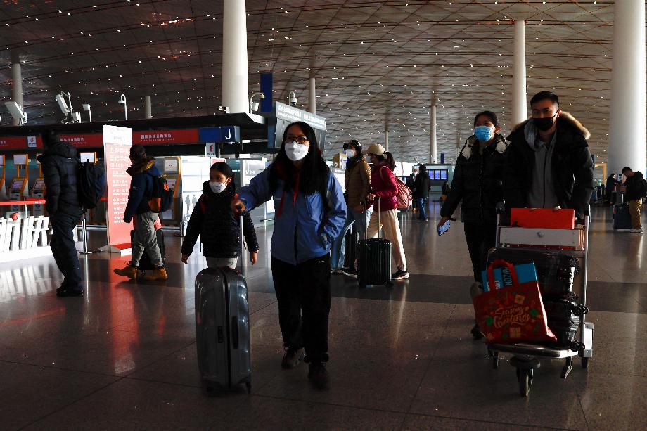 Les voyageurs marchent avec leurs valises dans un terminal de l'aéroport international de Pékin, Pékin, Chine le 18 janvier 2023. REUTERS/Tingshu Wang