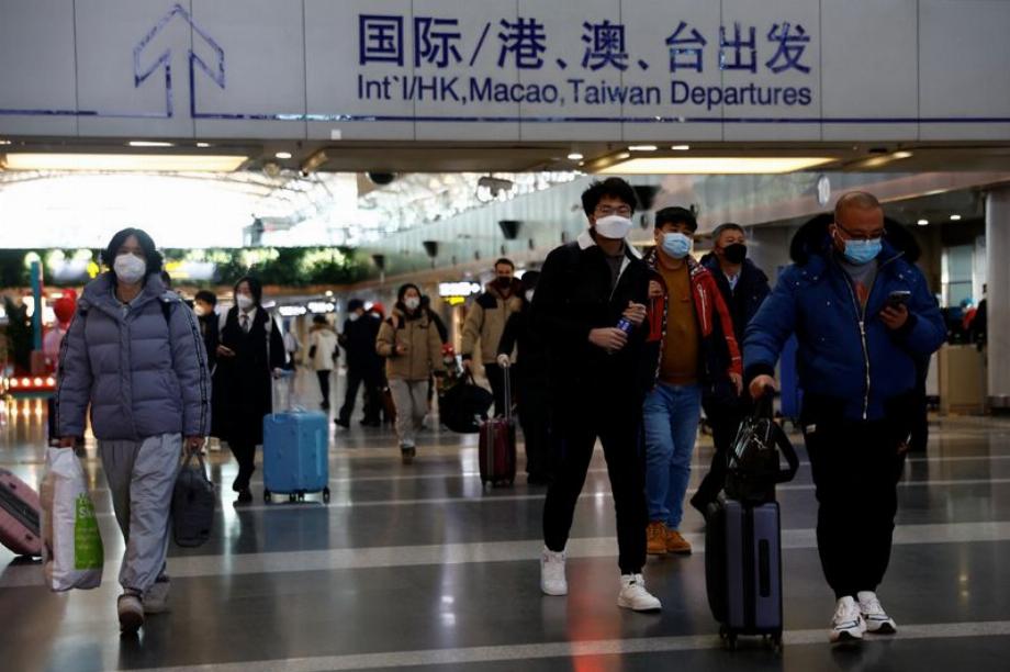 Les voyageurs marchent avec leurs bagages à l'aéroport international de Pékin, au milieu de l'épidémie de maladie à coronavirus (COVID-19) à Pékin, en Chine, le 27 décembre 2022. REUTERS/Tingshu Wang/File