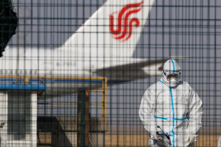Un travailleur portant une combinaison de protection marche près d'un avion de la compagnie aérienne Air China à l'aéroport international de Pékin alors que les épidémies de coronavirus (COVID-19) se poursuivent à Pékin en Chine, le 6 janvier 2023. REUTERS/Thomas Peter
