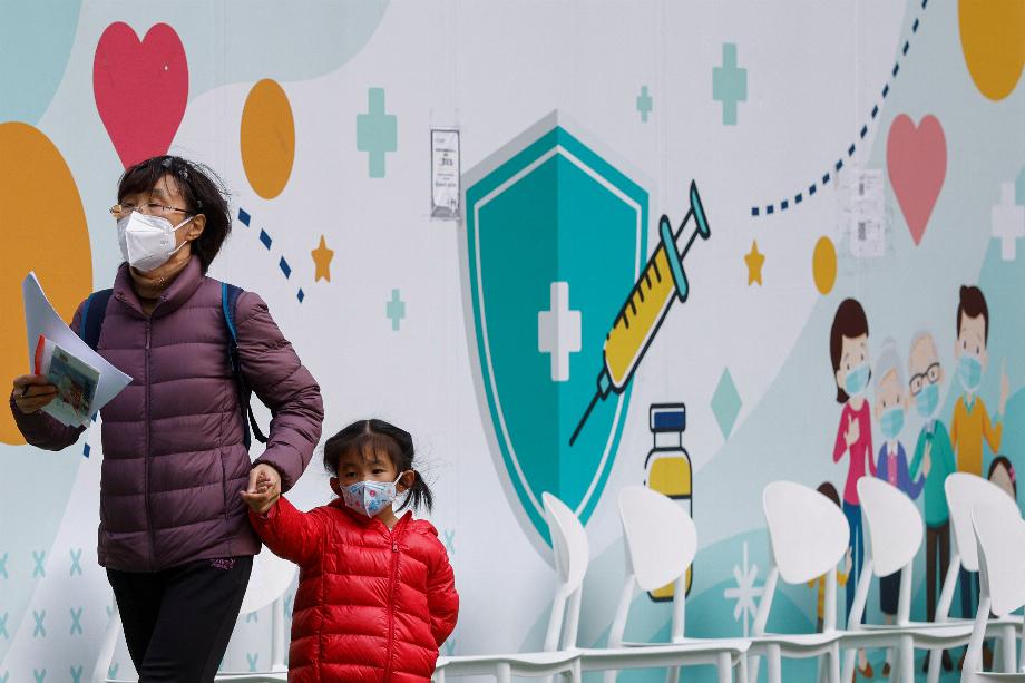 Une femme avec une petite fille dans un centre de vaccination communautaire, à Hong Kong, Chine, le 4 janvier 2023. REUTERS/Tyrone Siu