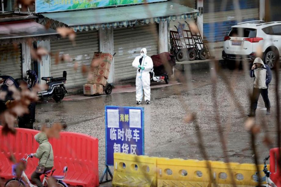 Un travailleur portant une combinaison de protection sur le marché fermé des fruits de mer à Wuhan, province du Hubei, Chine, le 10 janvier 2020 (REUTERS/Stringer)