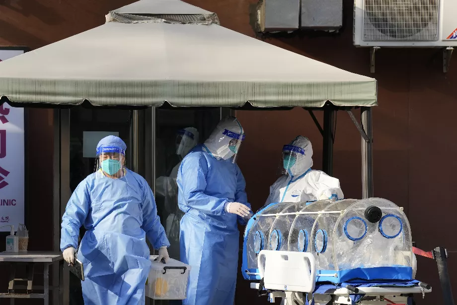 Des médecins en tenue de protection préparent leur équipement devant une unité de fièvre dans un hôpital de Pékin (AP)