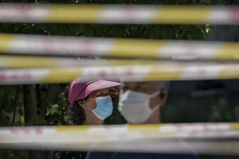 Des personnes portant des masques font la queue derrière des barricades pour subir des tests COVID à Pékin. (Photo AP/Andy Wong, dossier)